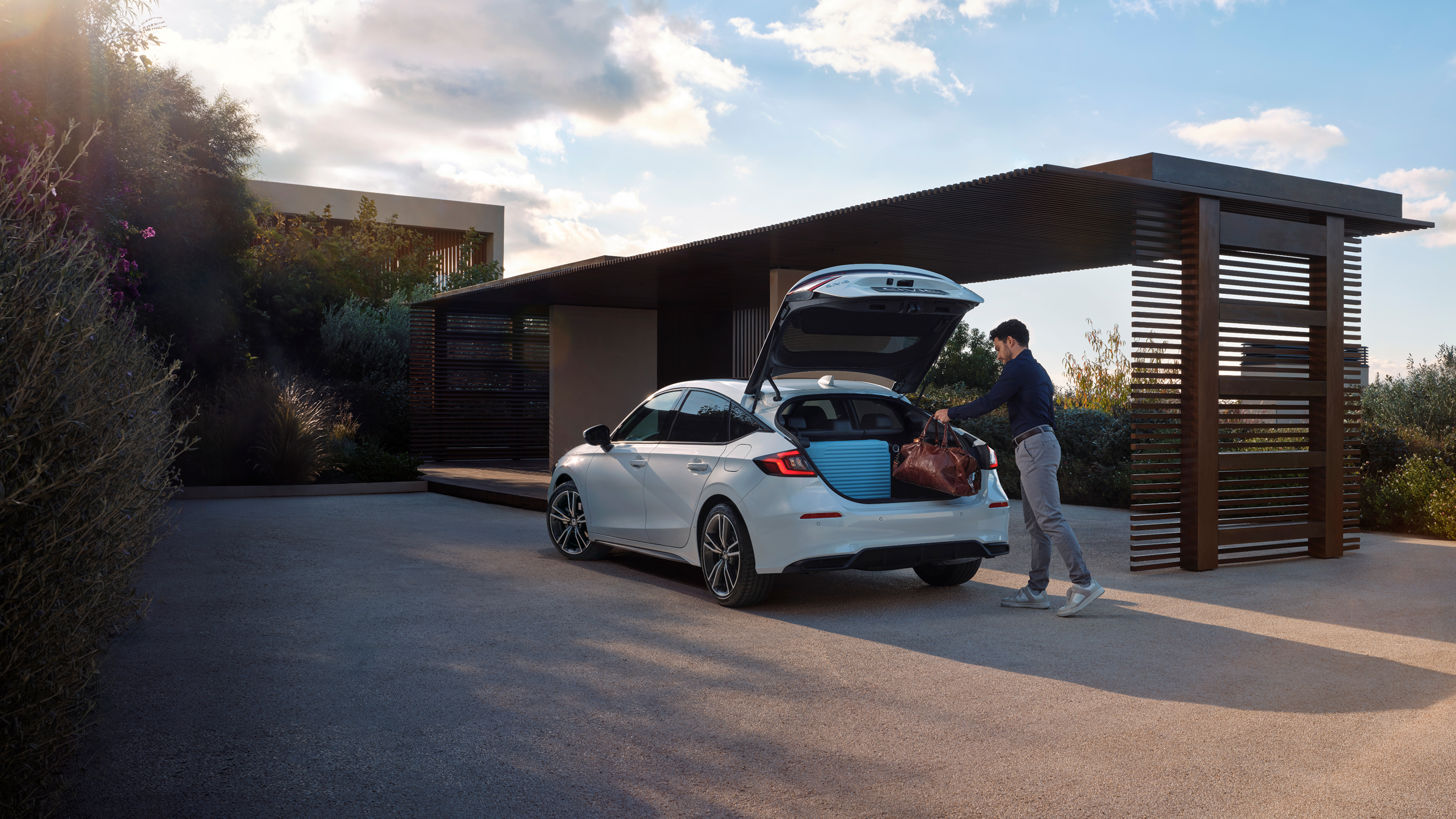 A person putting baggage in the Civic Hybrid's boot.